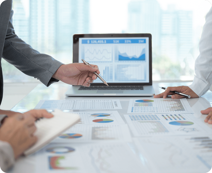 Analyzing data on laptop and papers